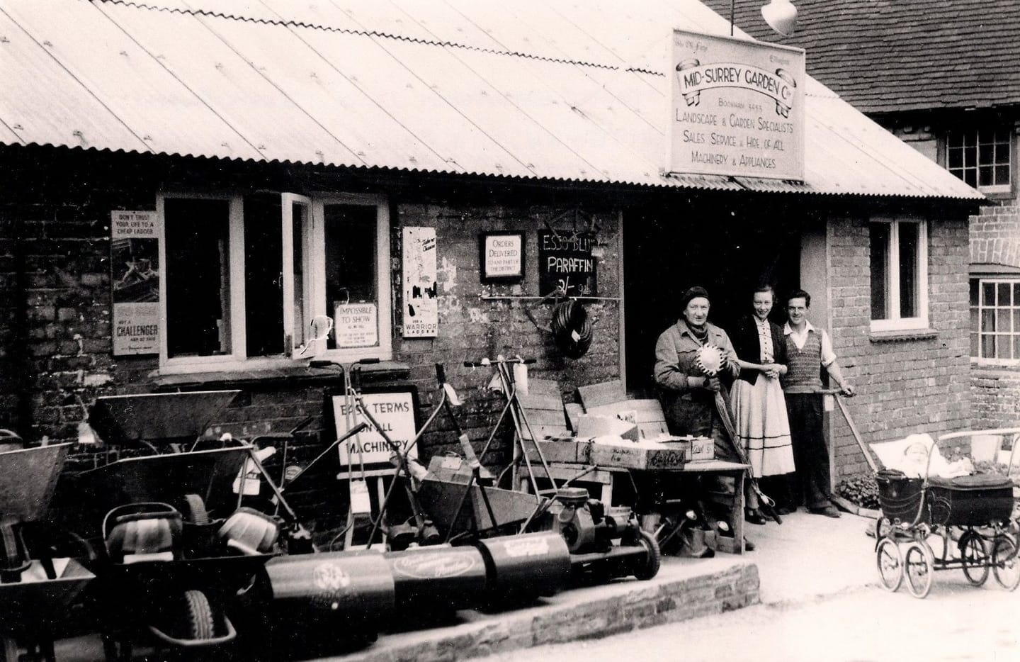 The shop team outside the Old Forge with mowers and garden machinery for sale