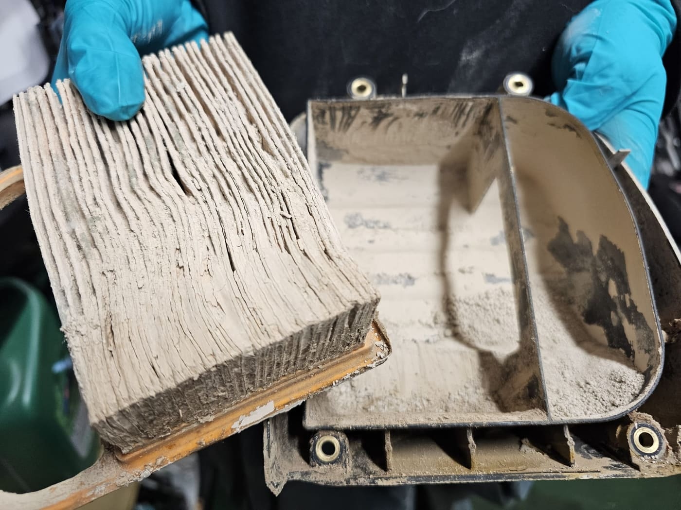 An air filter and airbox caked in fine dust