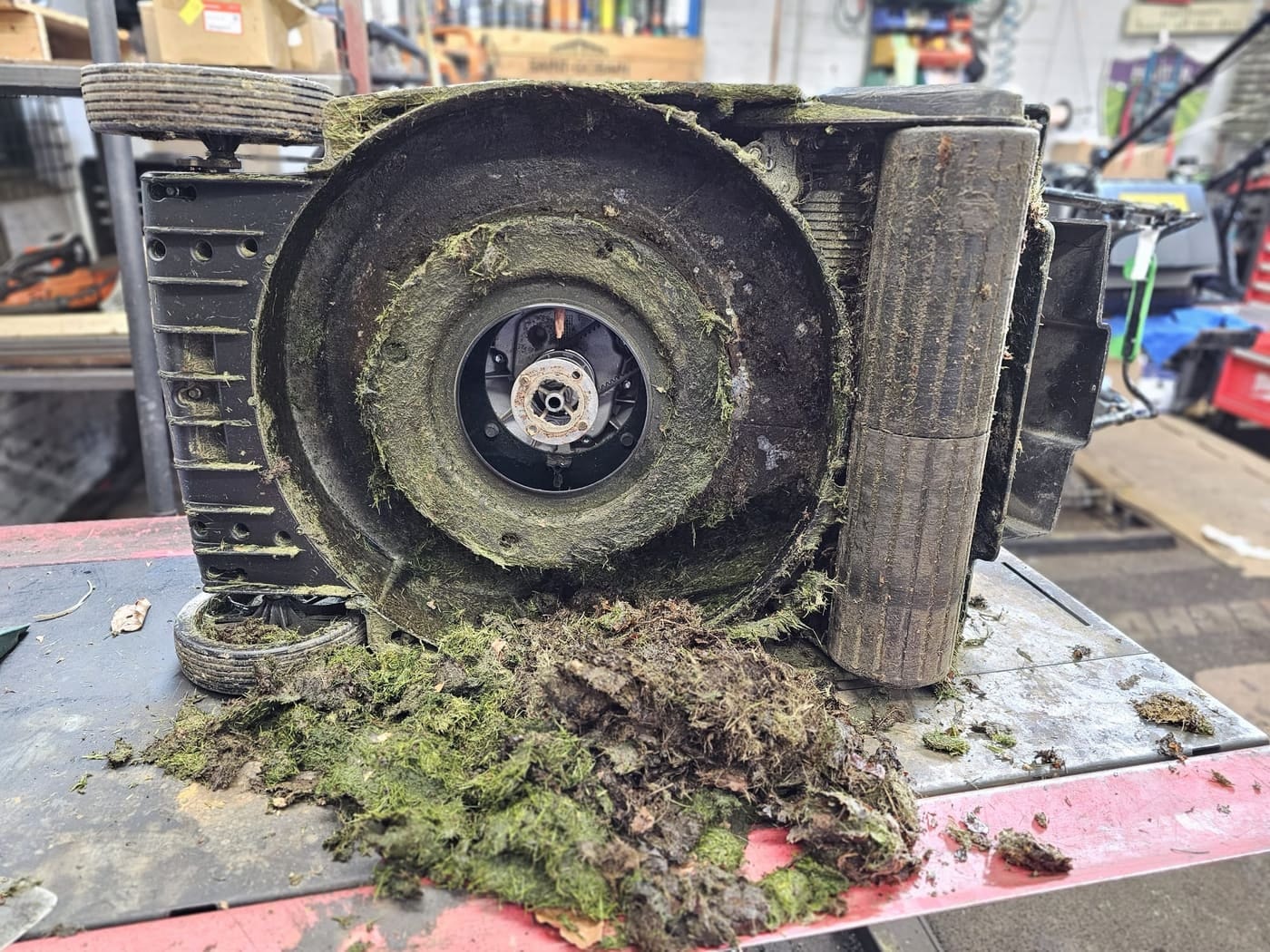 A thick mat of compacted grass and moss inside a Hayter mower deck