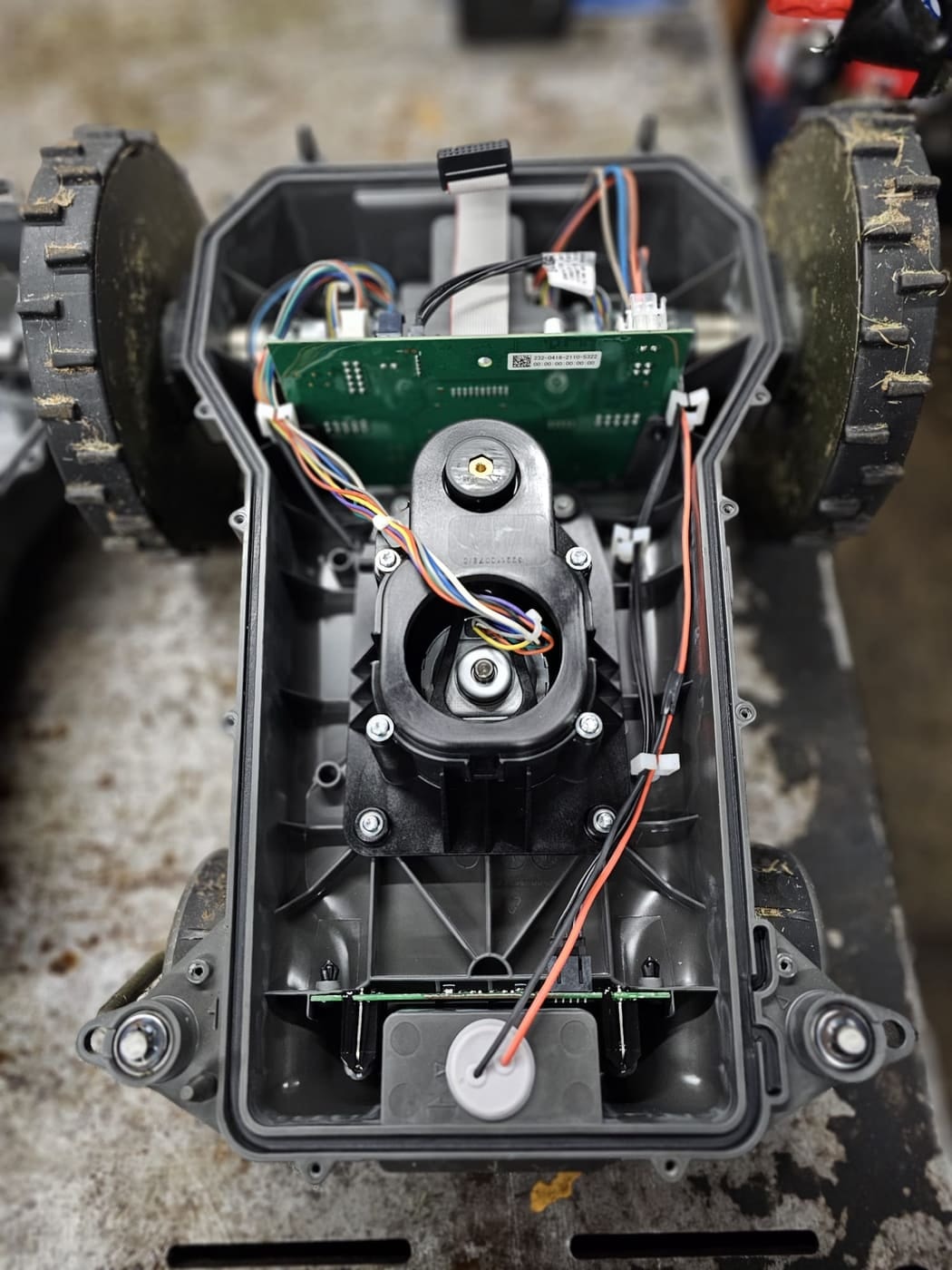 The drive motors, wiring and wheels of a Stiga robot mower