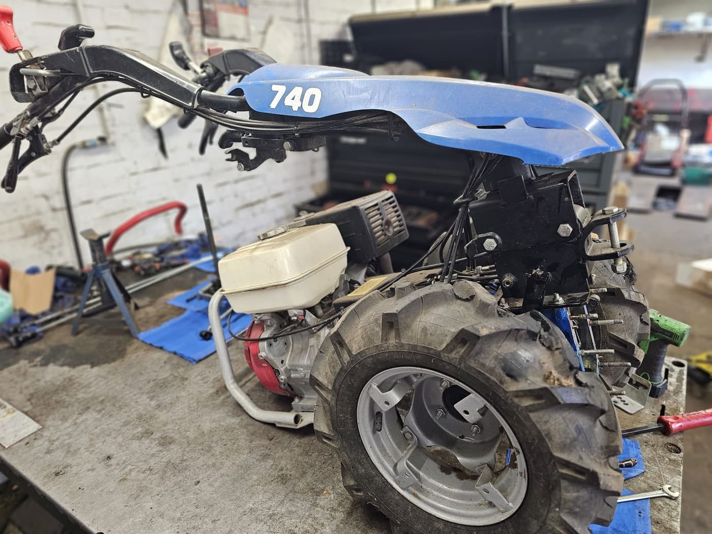 A two-wheel tractor with a Honda engine on the workshop bench